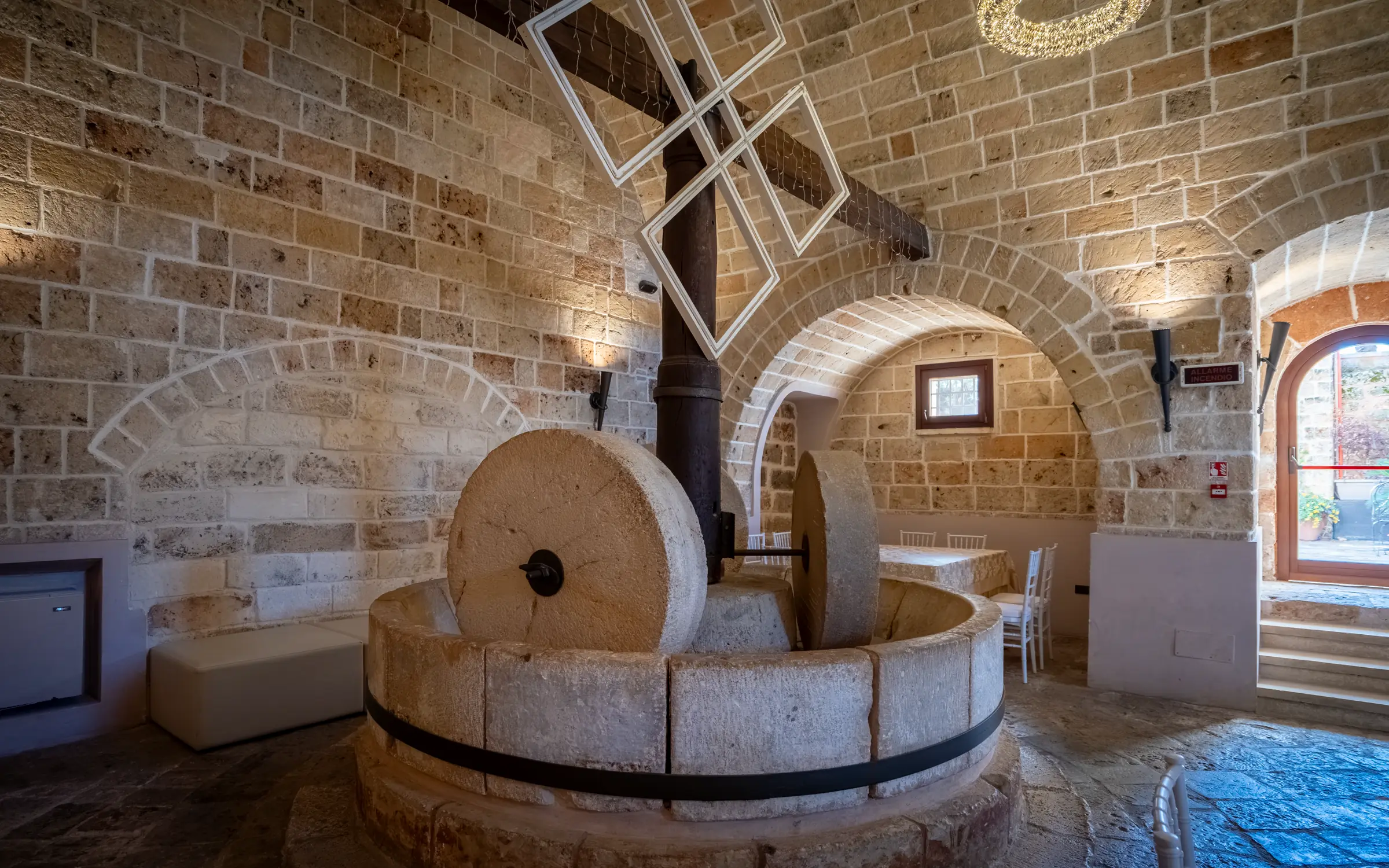 La macina in pietra del frantoio, con le due ruote e gli archi della sala ipogea